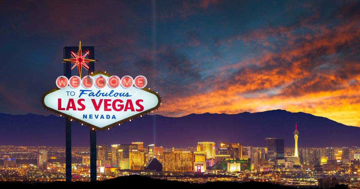 conic 'Welcome to Fabulous Las Vegas' sign illuminated at night, set against a vibrant sunset sky and the glowing Las Vegas skyline, symbolizing the excitement of Vegas Cannabis Week