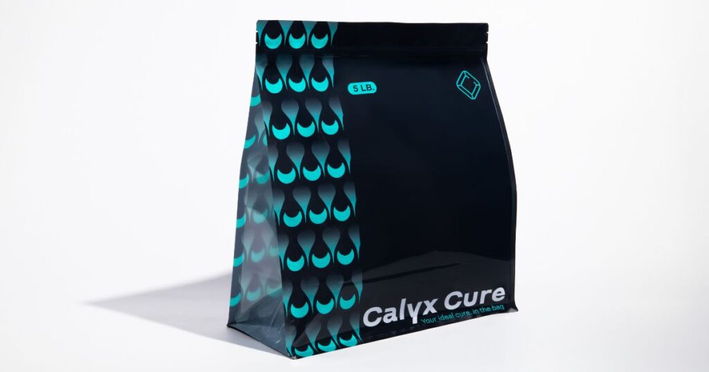 Glossy black stand-up pouch from Calyx Containers featuring a teal drop-like pattern and the text 'Calyx Cure' with the tagline 'Your ideal cure. in the bag,' showcasing modern cannabis packaging designed for durability and style