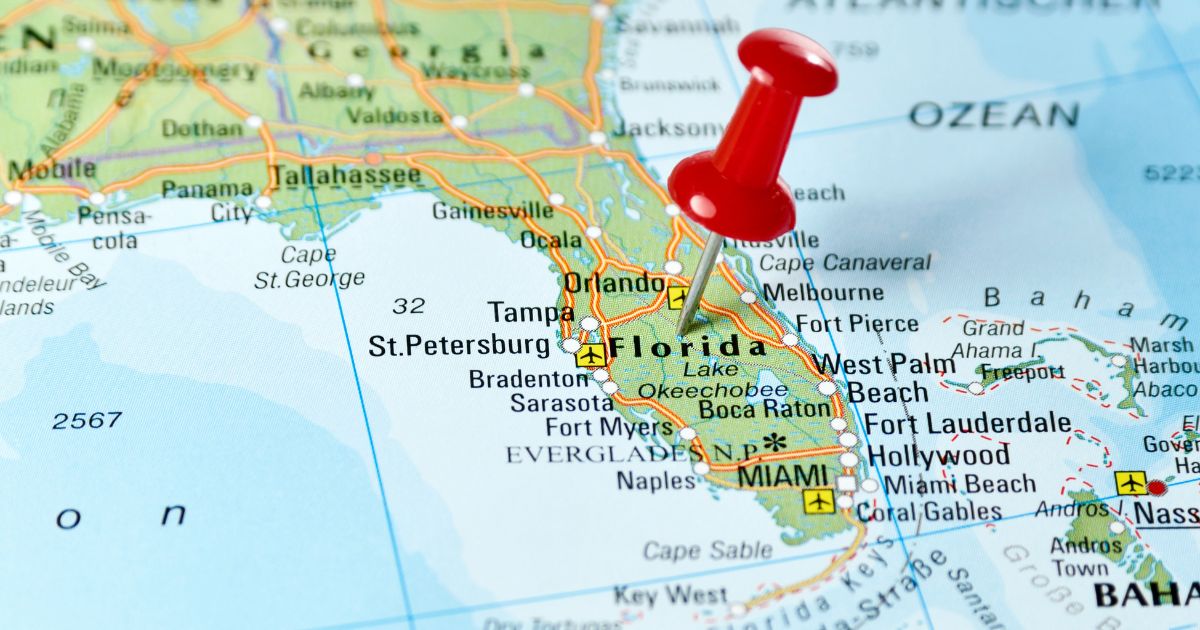 Close-up of a map highlighting Florida, with a red pushpin marking a central location near Orlando, surrounded by labeled cities, highways, and water bodies, symbolizing the focus of Florida Senate Bill 1398 on recreational marijuana and home grow proposals