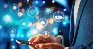 Person in a blue suit holding a smartphone surrounded by a glowing network of digital icons, symbolizing the interconnected strategies and tools essential for cannabis marketing in a tech-driven world