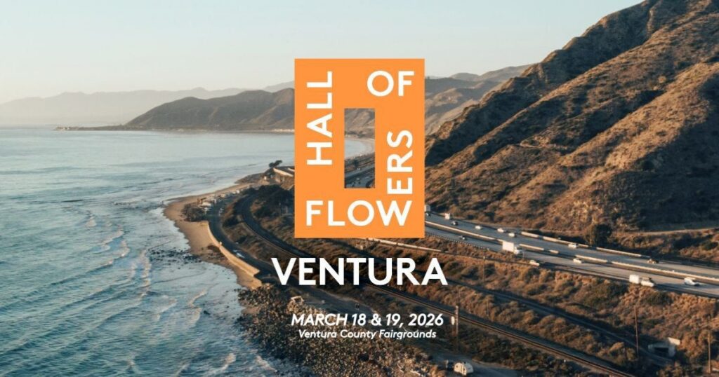 Aerial view of Ventura, California's coastline featuring the Pacific Ocean, a highway, and mountains. Overlaid is an orange graphic with the text 'HALL OF FLOWERS' and 'VENTURA 2026,' promoting the Hall of Flowers event in a scenic coastal setting