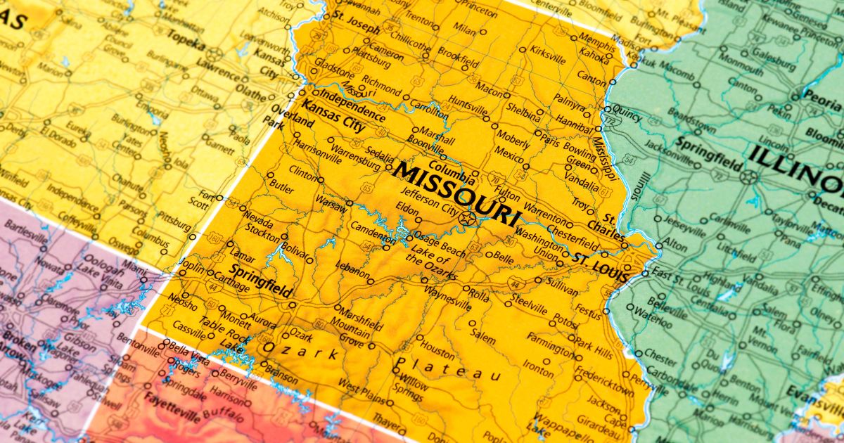 Close-up of a political map highlighting Missouri and its neighboring states, including Illinois, Kansas, Oklahoma, and Arkansas. Missouri is prominently displayed in yellow with major cities like Kansas City, St. Louis, and Springfield labeled, along with highways and rivers such as the Mississippi River. Keywords: Missouri microbusinesses rules