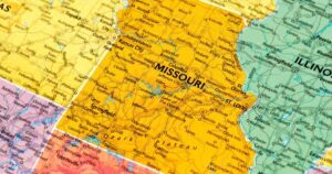 Close-up of a political map highlighting Missouri and its neighboring states, including Illinois, Kansas, Oklahoma, and Arkansas. Missouri is prominently displayed in yellow with major cities like Kansas City, St. Louis, and Springfield labeled, along with highways and rivers such as the Mississippi River. Keywords: Missouri microbusinesses rules