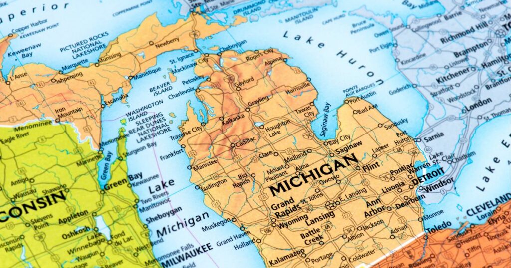 "Detailed close-up of a regional map highlighting Michigan, including major cities like Detroit, Lansing, and Grand Rapids, along with surrounding areas in Wisconsin and Ontario, Canada. The map features key highways, lakes such as Lake Michigan and Lake Huron, and notable landmarks. The focus on Michigan signifies the ongoing wholesale cannabis tax lawsuit in the state