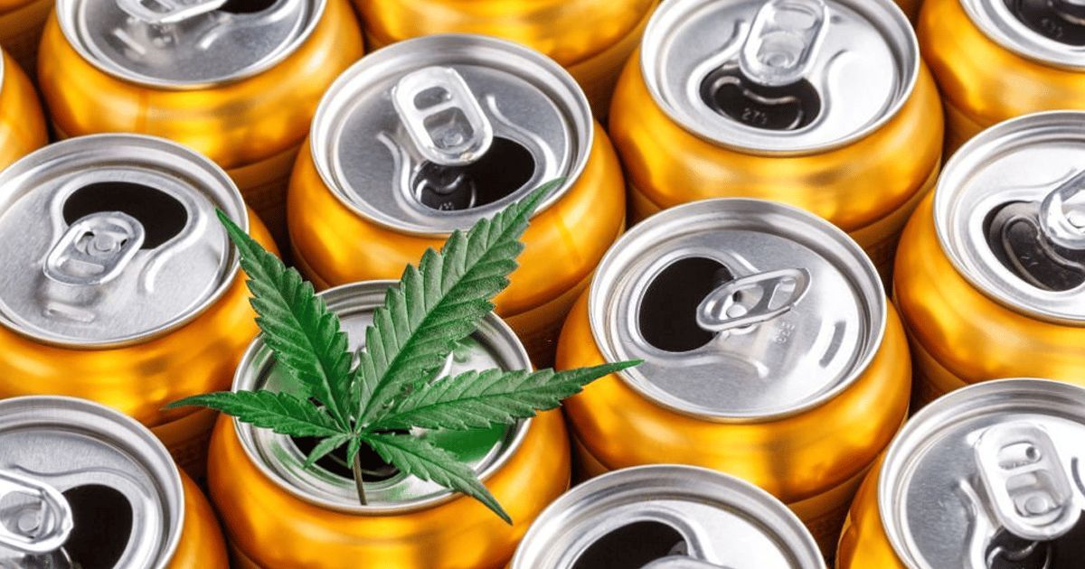 Top view of open gold beverage cans with a green cannabis leaf placed in the center, illustrating the hemp THC drink market.