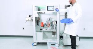 Technician operating the XB Automated Vape Cart Bagging System in a clean manufacturing space, with Xylem-branded machinery, digital controls, and vape packaging output visible.