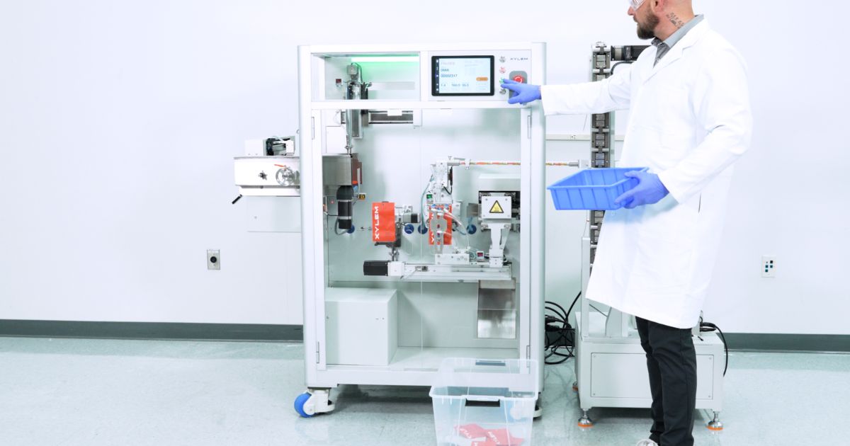 Technician operating the XB Automated Vape Cart Bagging System in a clean manufacturing space, with Xylem-branded machinery, digital controls, and vape packaging output visible.